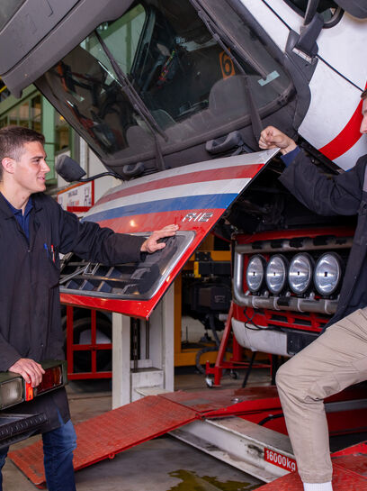 twee studenten mobiele werktuigen bij vrachtwagen