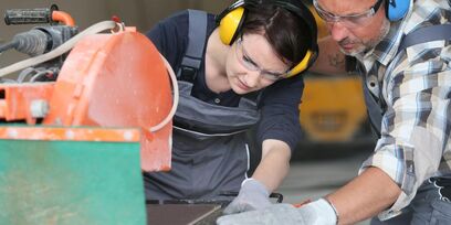 Student snijdt tegels met instructeur