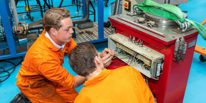 Twee studenten van de opleiding Eerste onderhoudsmonteur meet- en regeltechniek repareren een component. 